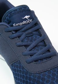 Baskets KangaROOS bleu marine avec mesh en tissu et empiècements en daim, dotées de lacets assortis et du logo de la marque sur la languette.