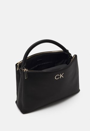 Czarna skórzana torebka z zaokrąglonym uchwytem, złotym zamkiem błyskawicznym i złotym logo "CK" z przodu, pokazana częściowo otwarta.