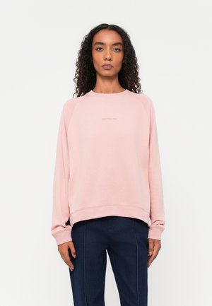 Lichtroze sweatshirt met een ronde halslijn en lange raglanmouwen. Subtiele logo-opdruk op de borst. Zachte stof, comfortabele pasvorm.