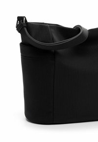 Schwarze, strukturierte Tote-Tasche mit einem geschwungenen Griff, die senkrechte Streifen und eine strukturierte Form aufweist. Robustes Gewebe mit einer eleganten Oberfläche.