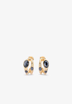 Pendientes de aro de oro con tres piedras preciosas azul oscuro de tamaños variados colocadas de forma asimétrica en cada pendiente.