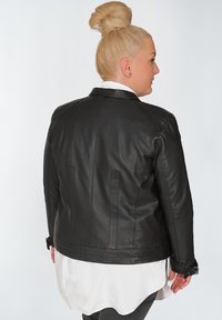 Schwarze Lederjacke mit strukturiertem Design, glatter Textur und Ein-Knopf-Verschluss, mit doppelten Rückenbelüftungen und verstellbaren Manschetten.