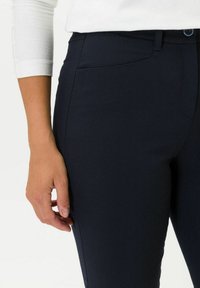 Pantaloni su misura blu navy con una texture liscia, tasche frontali e chiusura con bottone, dotati di vita media e design slim fit.