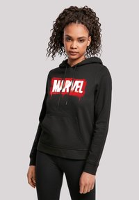 Felpa nera con cappuccio realizzata in misto cotone, caratterizzata da un grande logo "MARVEL" rosso e bianco sulla parte anteriore e una tasca a marsupio.