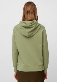 Lichtgroene hoodie met een zachte textuur, voorzien van een capuchon, ribgebreide manchetten en een rechte zoom. De achterkant toont minimale ontwerpdetails.