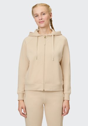 Beige zip-up hoodie with a drawstring hood, ribbed cuffs, and a smooth texture. Features a gold zipper and front pockets.