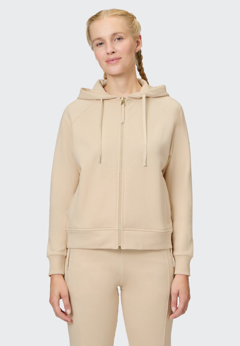 Beige zip-up hoodie with a drawstring hood, ribbed cuffs, and a smooth texture. Features a gold zipper and front pockets.