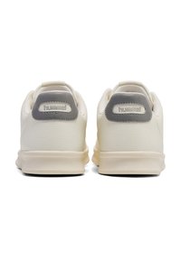 White leather sneakers with a textured surface and light grey accents on the heel. Features a low profile and cushioning for comfort.
