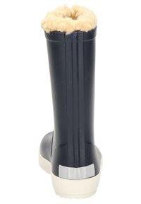 Botte en caoutchouc marine avec une finition texturée, doublure en fausse fourrure douce en haut, et semelle blanche pour l'adhérence ; présente un accent argenté sur le talon.