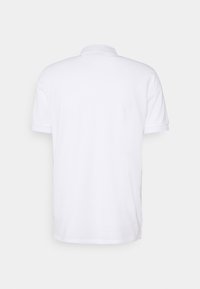 Polo blanc à manches courtes en coton, doté d'un col classique, de poignets côtelés et d'un ourlet droit avec des fentes latérales.