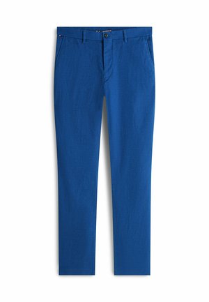 Pantaloni blu a taglio aderente con chiusura frontale a bottone e zip, tasche laterali e passanti per cintura su sfondo bianco.
