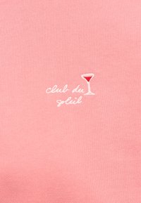 Tessuto di cotone rosa con ricamo della scritta "club du" e un'icona di bicchiere da cocktail con dettagli rossi. Texture morbida, design semplice.