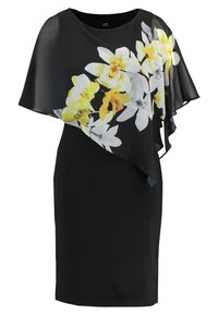 Robe noire avec un cape transparente ornée de motifs floraux blancs et jaunes. Tissu lisse, encolure ronde et coupe jusqu'aux genoux.