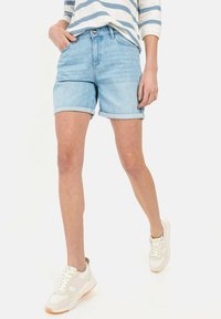 Lichtblauwe denimshorts met omgeslagen randen, voorzien van een klassiek vijf-pocket ontwerp en een relaxte pasvorm. Draagt met witte sneakers.