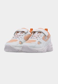 Baskets de sport en mesh blanc et orange avec des scratchs, des lacets et des semelles épaisses texturées, placées côte à côte sur un fond blanc.