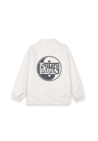 Biała lekką kurtka z kołnierzykiem, elastycznymi mankietami i dużą czarną grafiką yin-yang z napisem "GRIMEY" na plecach.