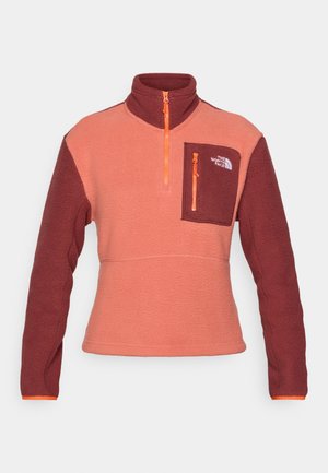 Korallroosa ja tumepunane fliispullypool, millel on poolne lukku, rinna tasku ja kontrastsed oranžid lukud. Tekstuuriga kangas pika varrukaga.