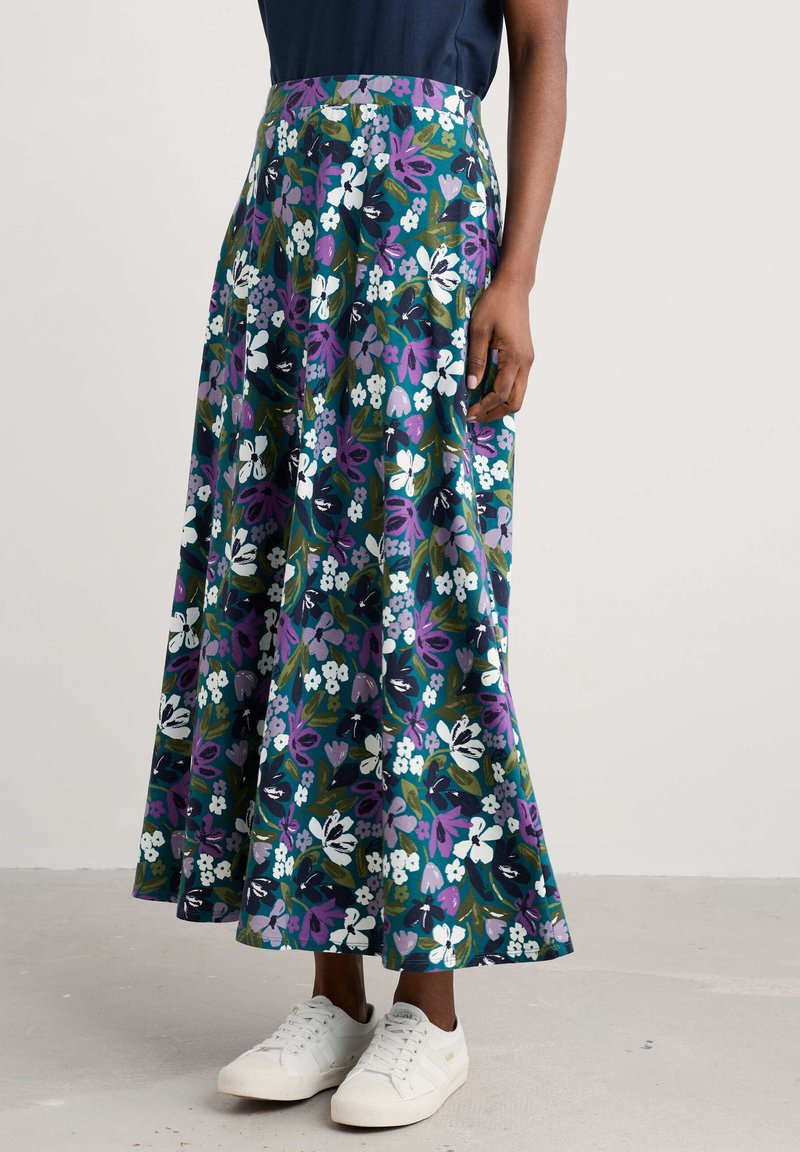 Floral maxi skirt in dark green with purple, white, and blue flowers. Made of lightweight fabric; features a fitted waistband and flared silhouette.
