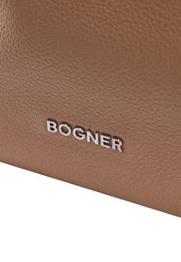 Borsa in pelle texturizzata marrone con logo "BOGNER" in argento in basso a destra. Design pulito e minimale con bordi morbidi.