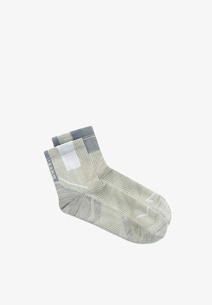 Paar knöchellange Socken in Hellgrau mit weißen und dunkelgrauen geometrischen Mustern und gerippten Bündchen.