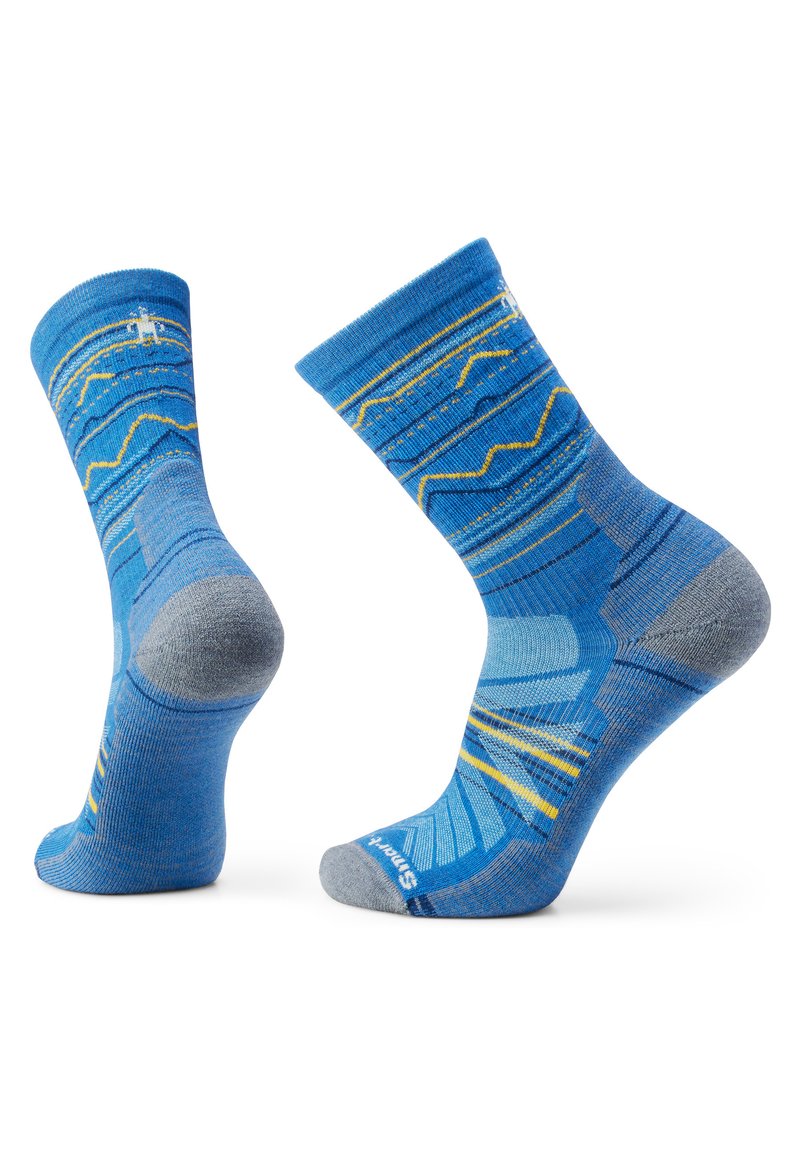 Calcetines azul y gris con un patrón de diversas olas en tonos de azul y amarillo, con refuerzo en el talón y la puntera.