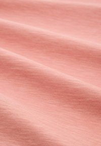 Tessuto rosa morbido con una fine trama e pieghe sottili che creano onde delicate sulla superficie.