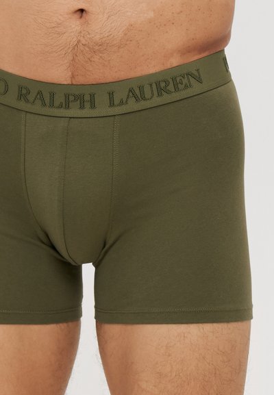Olívazöld boxer alsónemű, puha anyagból, rugalmas derékrésszel, amelyen a "RALPH LAUREN" logó szerepel. Szoros illeszkedésű dizájn és sima textúra.