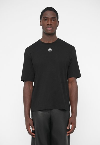 Zwart T-shirt met korte mouwen, gemaakt van katoen, met een ronde hals en een klein cirkelvormig embleem op de borst. Eenvoudig design, losse pasvorm.
