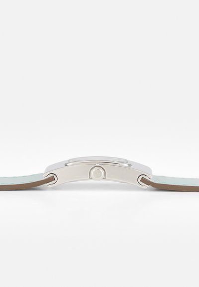 Orologio con cassa in metallo argentato e quadrante rettangolare, dotato di un cinturino in pelle blu chiaro e di una parte inferiore in pelle marrone.