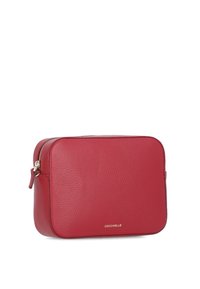 Borsa crossbody rettangolare in pelle rossa con superficie texturizzata, chiusura a zip e dettaglio con logo. Design compatto per uso quotidiano.