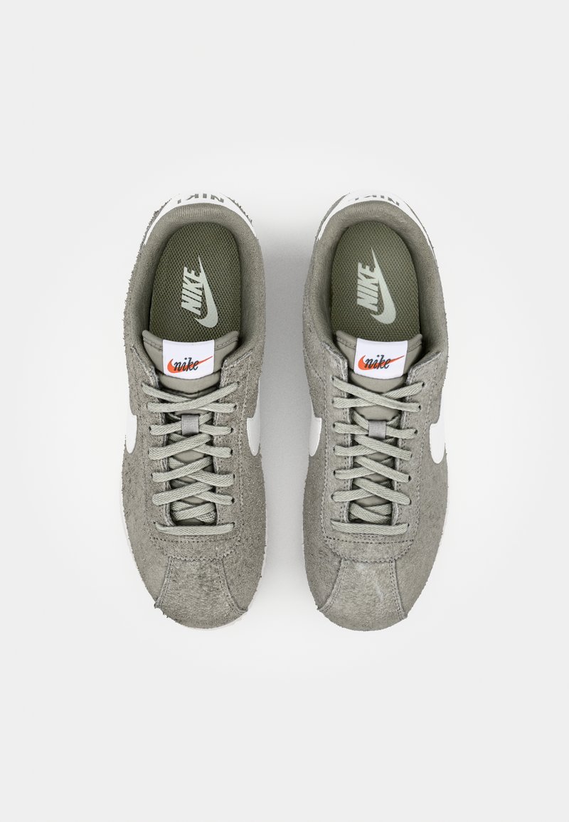 Sneaker in suede grigio con accenti bianchi, dotati di design con lacci, suole imbottite e branding sulla linguetta e sulla suola interna.