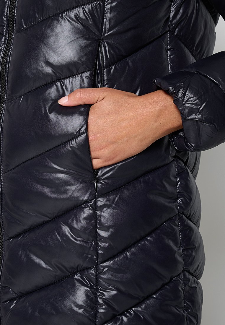 Pufferjack in glanzend zwart nylon met chevron-quilten; heeft een zijzak en een rits. Soepele textuur met gewatteerde isolatie.