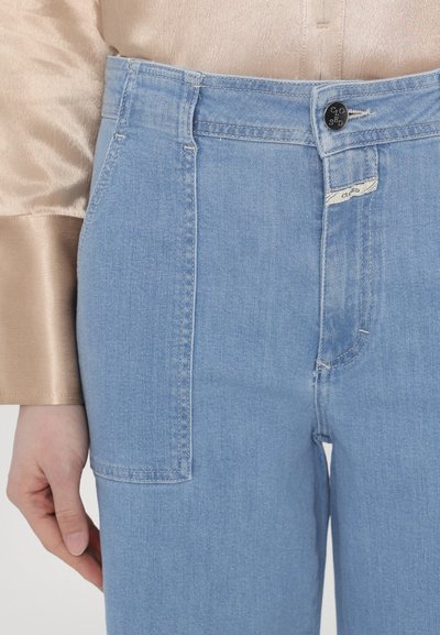 Light blue denim jeans with a high waist, featuring a front pocket, subtle stitching, and a button closure at the waistband.