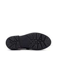 Suela de zapato de goma negra con una superficie texturizada y estampada, con surcos de tracción distintivos y una zona de punta redondeada.