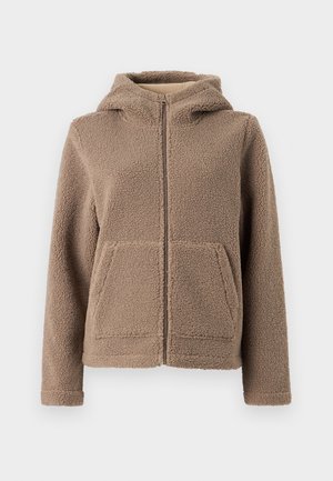 Fleece zip-up hooded jacket in light brown, featuring a soft, textured exterior, two front pockets, and a relaxed fit.