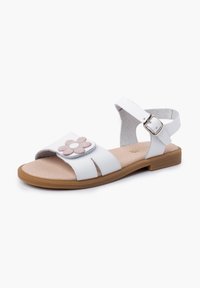 White sandal with a soft pink flower accent, ankle strap with buckle, open toe design, and flat rubber sole. Smooth leather texture.