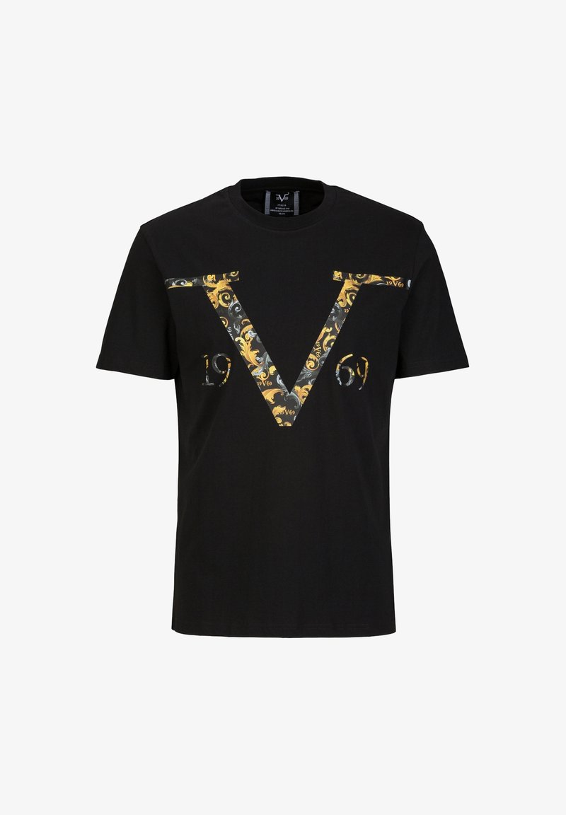 Schwarzes T-Shirt mit einem großen dekorativen gold- und graumusterierten Buchstaben V über der Brust, dazu das Jahr "1969" darunter.