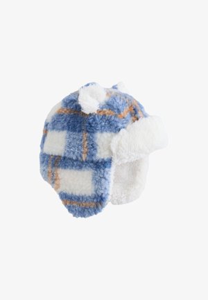 Căciulă pufoasă cu model în carouri albastru și alb, cu clape pentru urechi și margine de culoare deschisă, având un exterior texturat și pompoane în partea de sus.