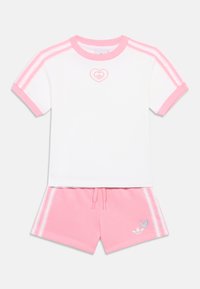 Rövid ujjú fehér felső rózsaszín részletekkel és szív logóval, rózsaszín rövidnadrággal, fehér csíkokkal és kék logóval. Pamut keverék anyag.