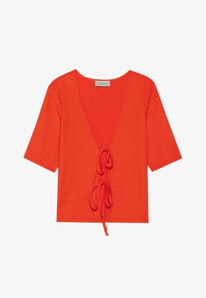 Top rojo acanalado con mangas cortas, escote en forma de V profundo y detalle de lazo ajustable en la parte frontal. Confeccionado en tela texturizada para añadir dimensión.