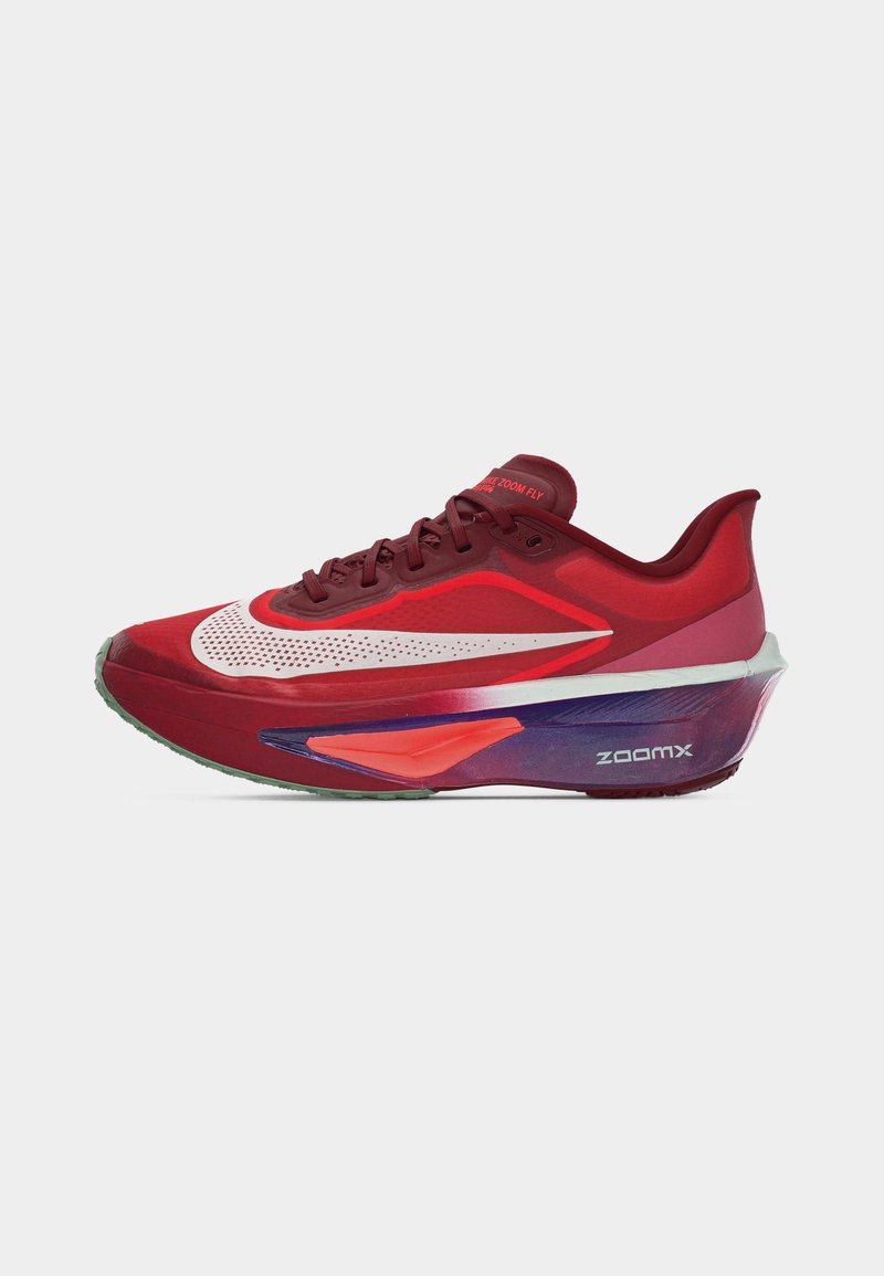Czerwony i różowy but do biegania z dużym białym logo Nike, podeszwą ZoomX z fioletowymi i pomarańczowymi akcentami oraz napisem "Nike Zoom Fly" na języku.