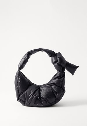 Sac à épaule matelassé noir avec une bandoulière nouée et un petit logo "Holzweiler" sur le devant sur fond blanc.