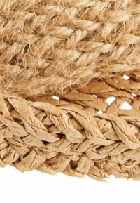 Naturalne włókno tkane w odcieniach beżu, o teksturowanej powierzchni z połączeniem luźno i ściśle zaplecionych włókien.
