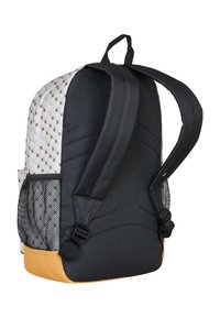 Plecak z pikowanym białym i złotym wzorem, czarną tkaniną na dole i ramiączkach, siateczkową kieszonką boczną oraz teksturowanym dnem w kolorze musztardowym.