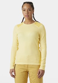 Žlutá dlouhá tričko s dlouhým rukávem vyrobené z lehkého materiálu, s kulatým výstřihem, bezšvovými rameny a variačními texturami na rukávech.