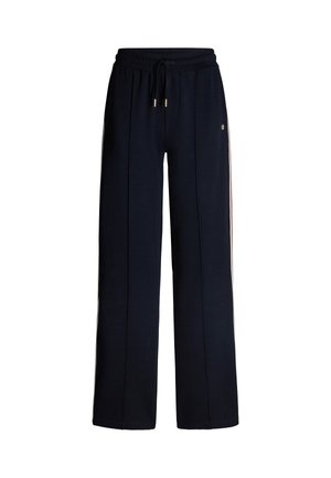 Pantalons de survêtement navy avec un design à jambes larges, taille élastique, fermeture à cordon de serrage et rayures crémeuses sur les côtés. Fabriqués en tissu doux et texturé.