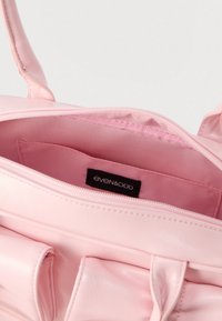 Bolso sintético rosa con textura lisa, cierre de cremallera y interior forrado. Cuenta con una etiqueta que dice "even&odd" en el interior.