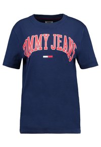 Námořnická modrá bavlněná tričko s nápisem "TOMMY JEANS" v tučných červených písmenech. Obsahuje malý detail vodorovného pruhu v červené, bílé a modré barvě.