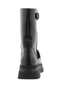 Bota de cuero negro hasta el tobillo con punta redonda, hebilla lateral y suela de goma estriada. Presenta una textura suave y un diseño de caña alta.