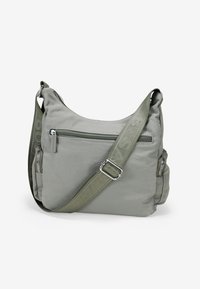 Bolso cruzado de color gris claro, hecho de un tejido suave, con una correa ajustable en color verde oliva, bolsillo delantero con cremallera y detalles con cremallera en los laterales.